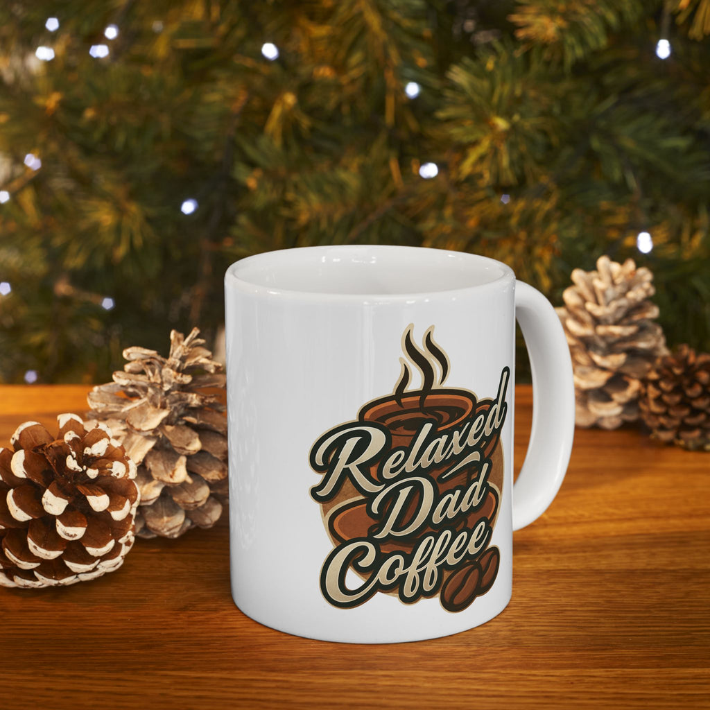 White coffee mug with 'Relaxed Dad Coffee' text and coffee cup graphic on wooden table with pine cones