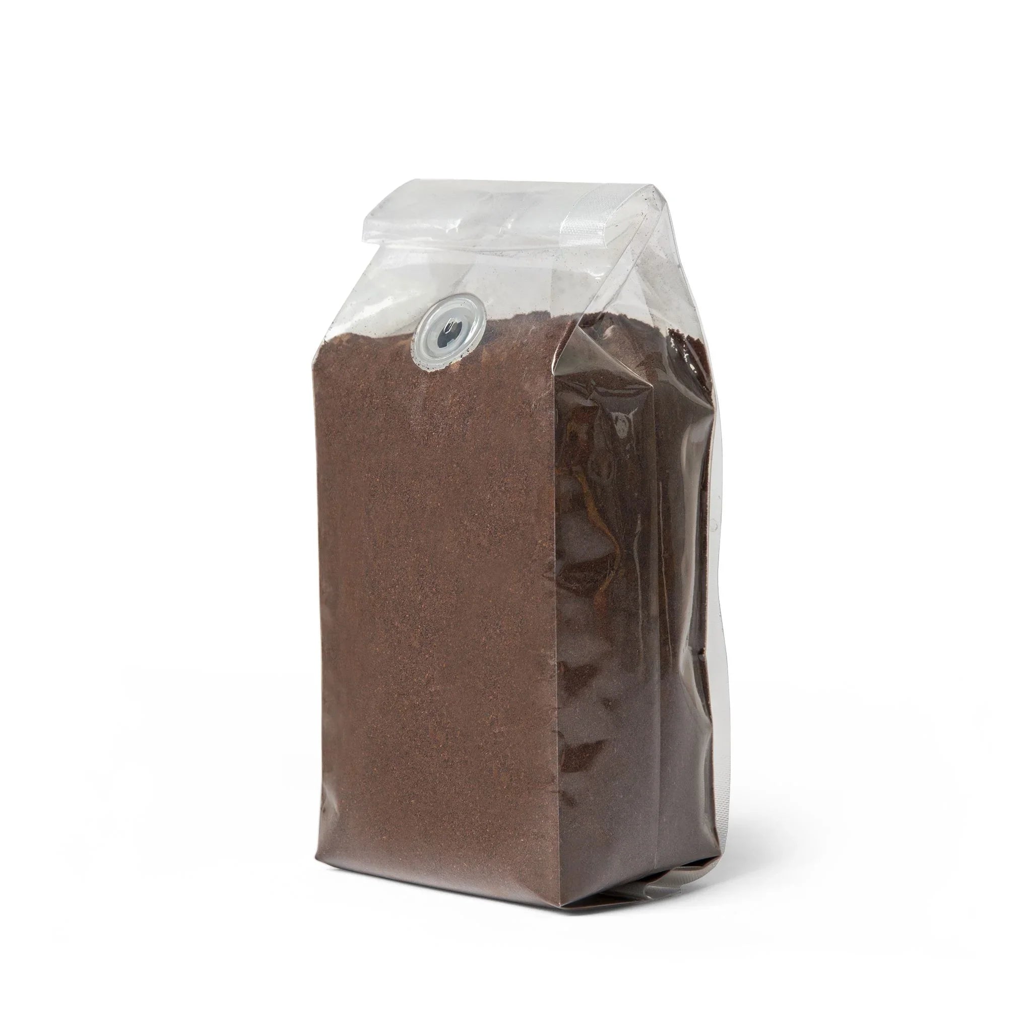 Clear plastic bag filled with dark ground coffee beans, featuring a one-way valve